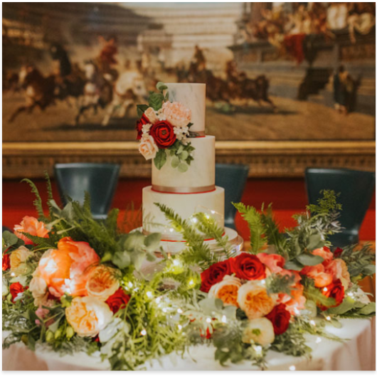 Wedding cake and red and peach flowers in front of the Chariot Race
