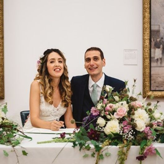 Couple signing the register, flower bouquet on the table