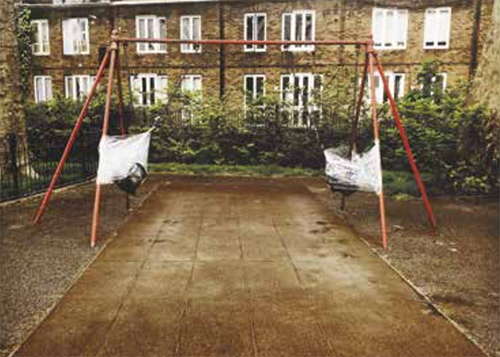 Swings in a park have been taped to the bars at the side so they can't be used