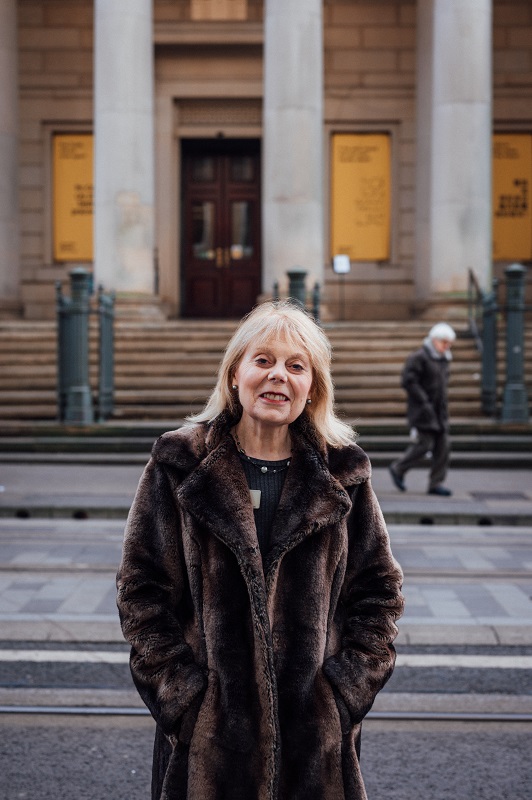 Portrait of Ann standing outside the entrance to the gallery