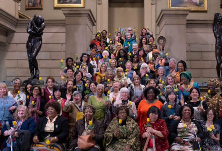 100 Women of Uncertain Futures project standing on the staircase at the entrance of Manchester Art Gallery