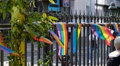 Pride flags blowing in the wind, attached to the railings of the gallery